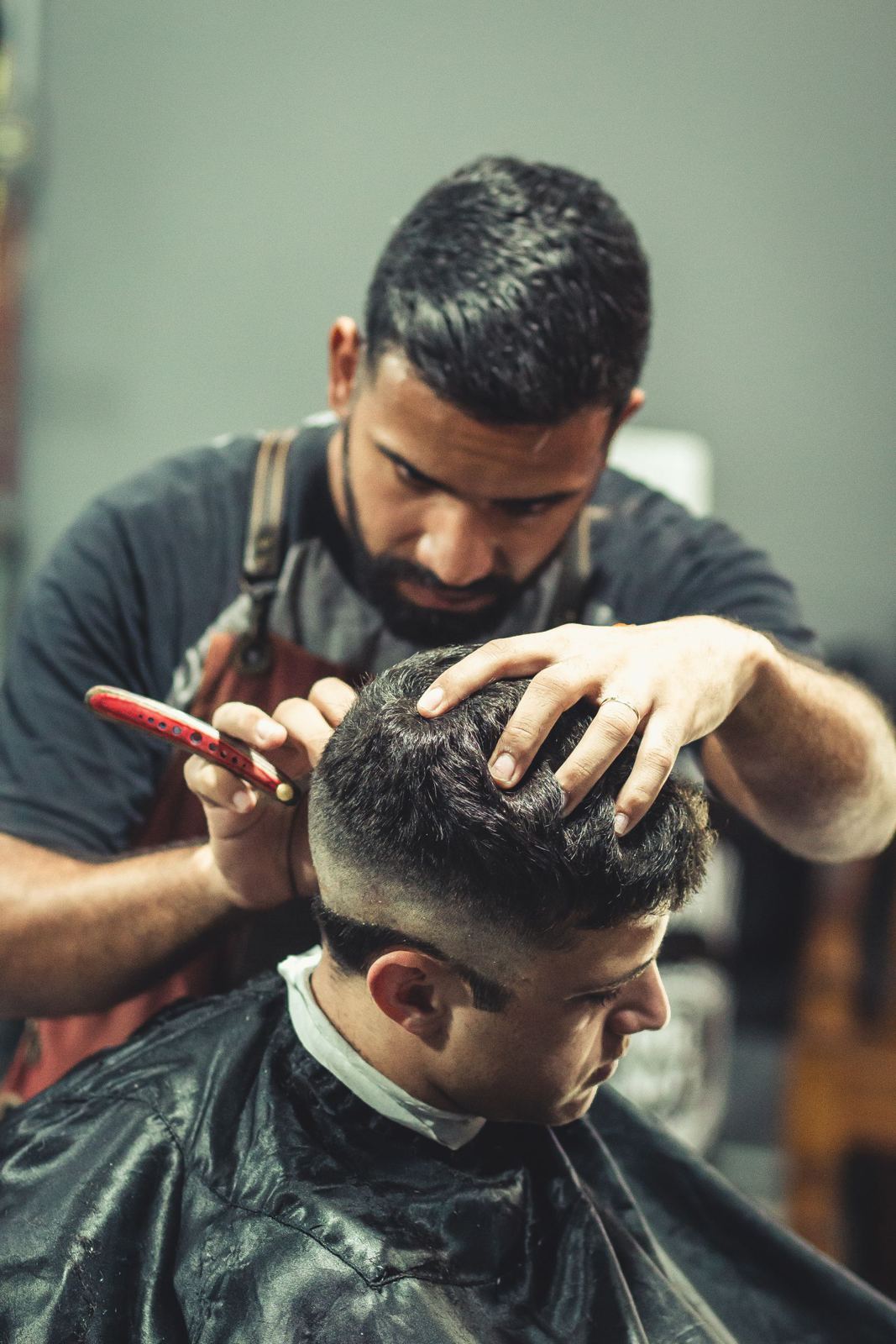 Barber shaping the top of a cut by hand