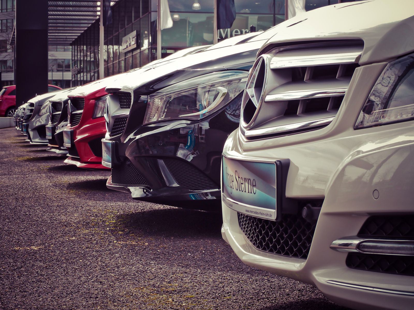 Row of premium cars lined up outside a dealership