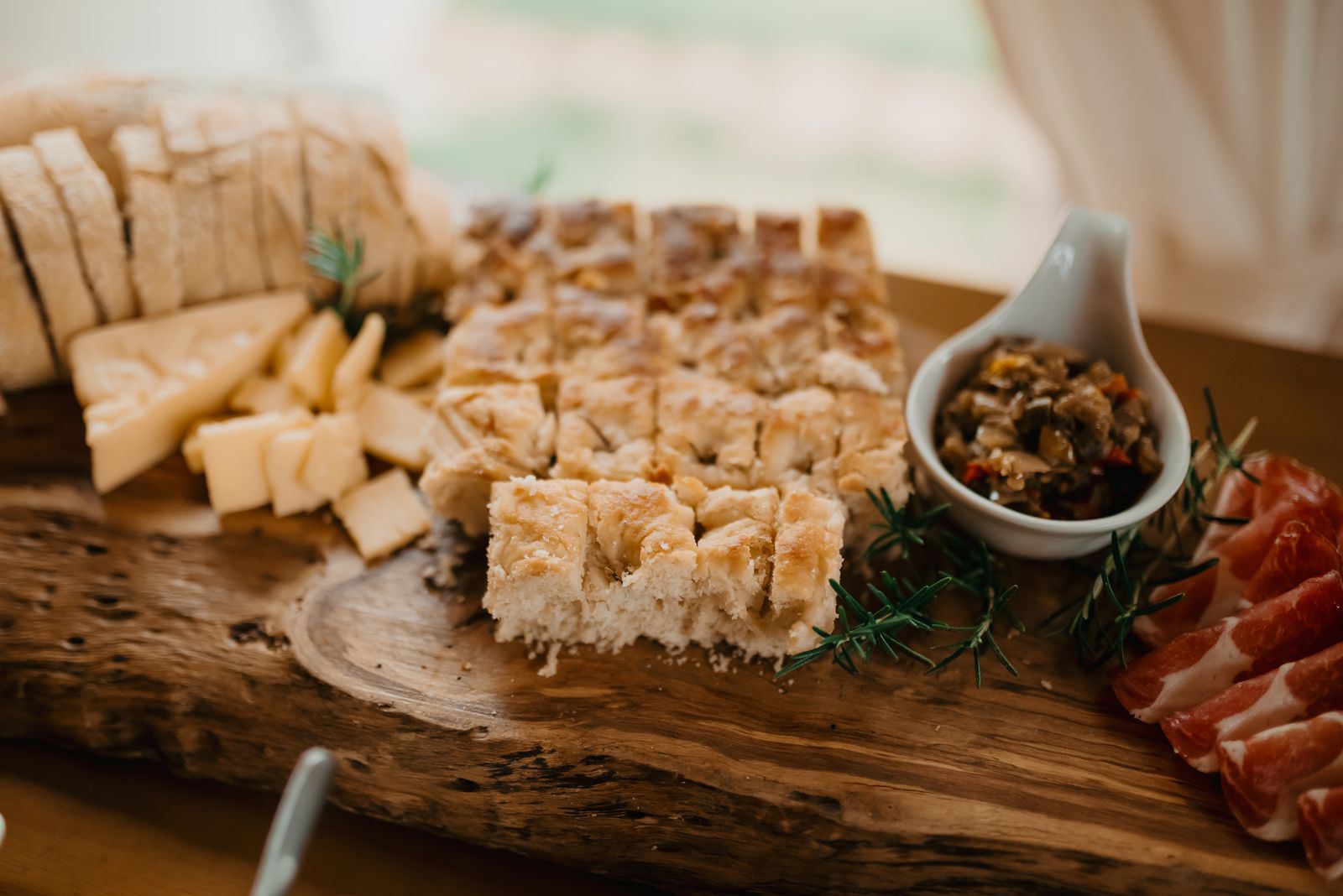 Focaccia, cheese and cured meat on a wooden board