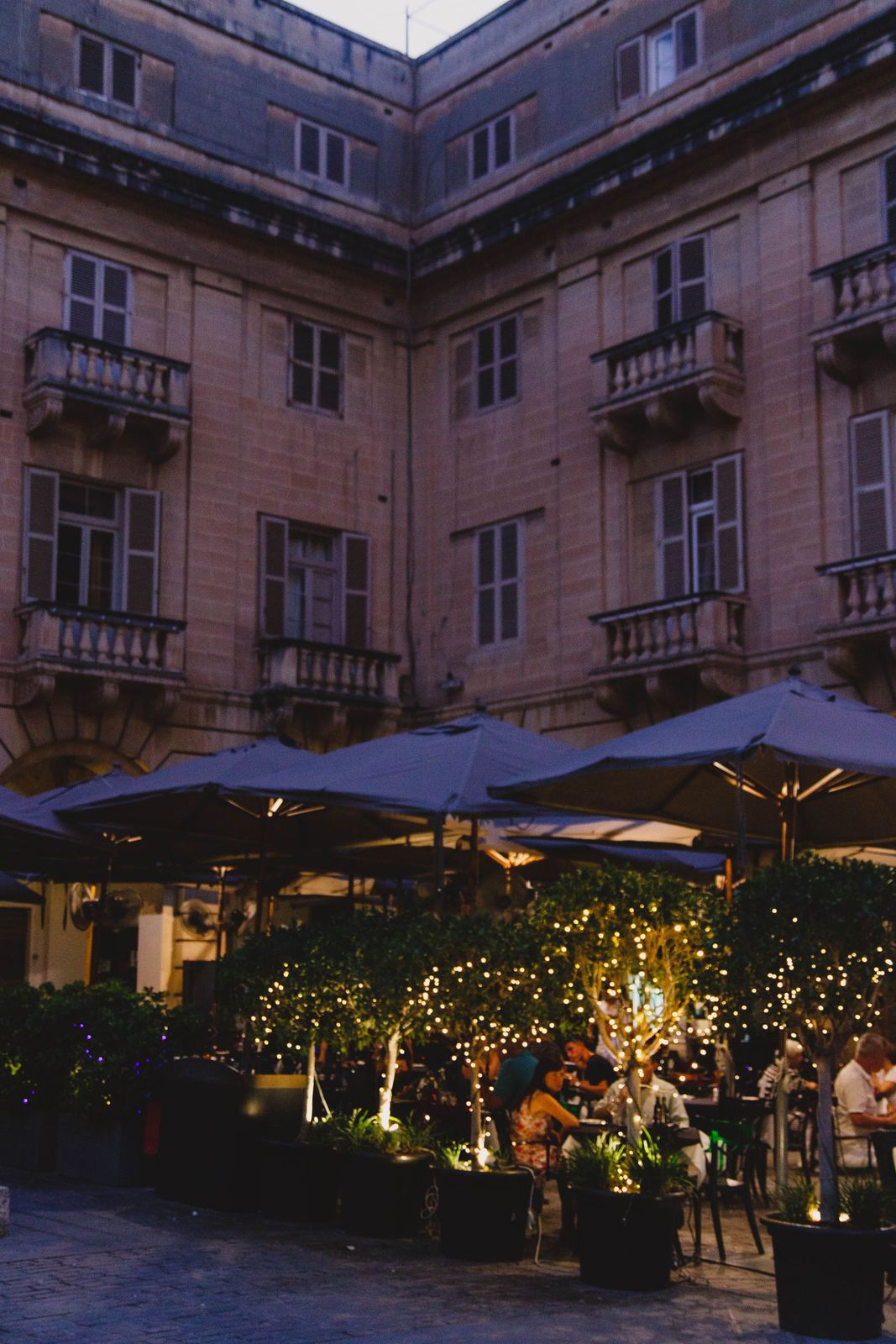 The courtyard at dusk under string lights